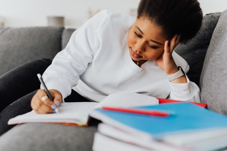 Senior student annotating an English text while drafting an essay